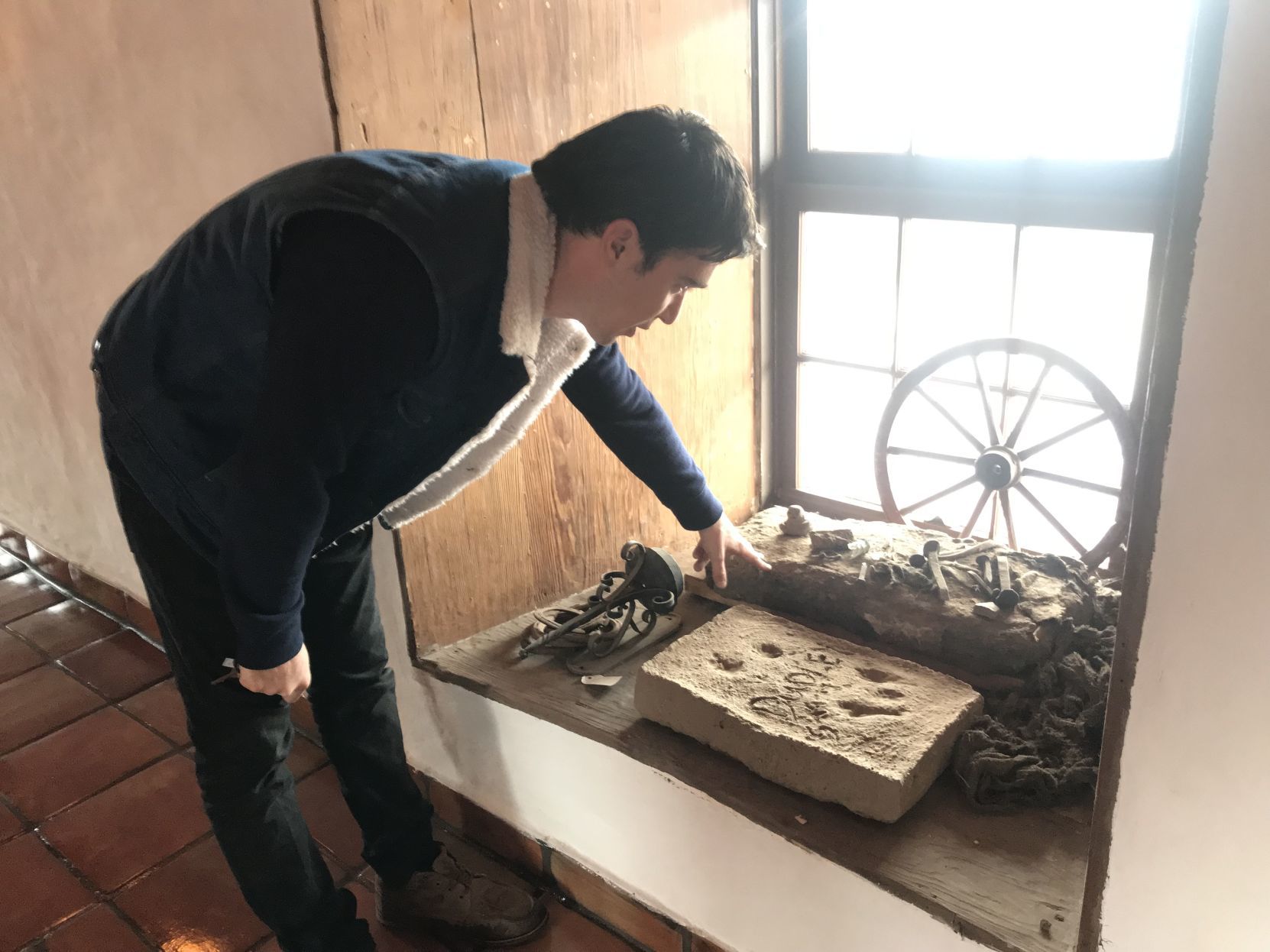 Justin Altamura compares adobe brick sizes at the old adobe in Napa